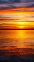 Obraz premium Fiery sunset colors reflect vividly on the tranquil water surface. Golden light streaks across the horizon, creating a stunning natural mirror effect ,glowing ,colorful ,horizon
