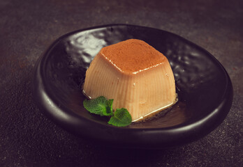 cream caramel pudding, with caramel sauce, dessert,breakfast, on a black plate, mint, no people,