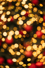 Soft-focused golden and red bokeh lights create a warm, festive, and magical abstract background perfect for holiday themes.
