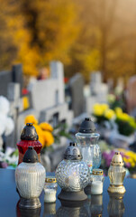 Święto Zmarłych. Znicze zapalone na grobie.