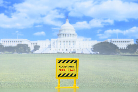 Close-up of yellow &ldquo;Government Shutdown&rdquo; sign in front of the U.S. Capitol building. Visual metaphor for budget freeze, federal services halt, political deadlock and economic danger.