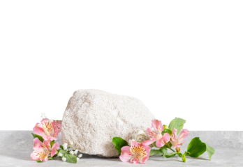 Soft white textured stone placed on light stone surface, decorated with delicate pink alstroemeria flowers and green leaves. Minimal spa or cosmetic product scene with clean transparence, copy space