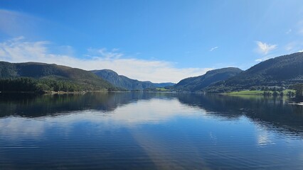 Perfect Blue Sky Reflection on Calm Fjord Water and Mountain Valley