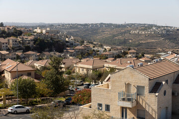 Obraz premium Gush Etzion, Israel 31 October 2025, Panoramic view of a well-established residential neighborhood of houses with light-colored stone facades and tiled roofs,