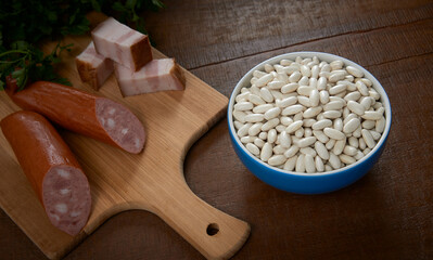 Tijela com feij&atilde;o branco cru, isolada em fundo de madeira