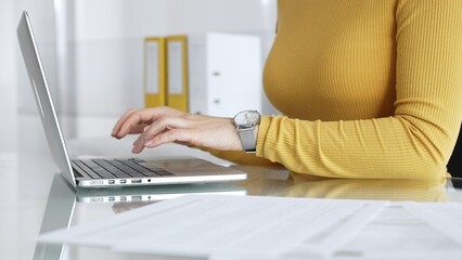 Fototapeta premium Woman freelancer working with digital tablet, browsing information, using online technology in modern office. Audit and taxes in business