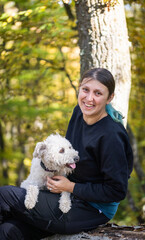 happy woman with dog enjoying autumn outdoors