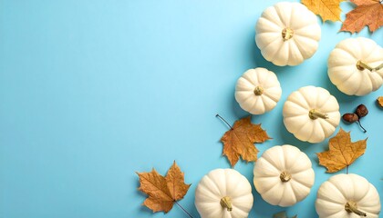 Autumnal Arrangement - White Pumpkins and Golden Leaves on Blue Background.