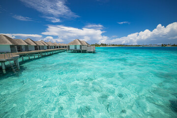 Luxury Maldives water villas. Relaxing sunny ocean lagoon, pristine sea bay blue sky calm water. Tranquil summer luxury tourism. Best popular resort view destination travel, wide angle panorama travel