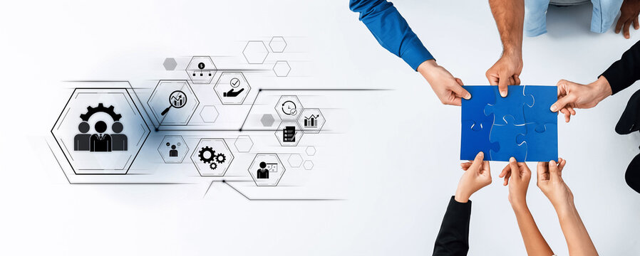 Fototapeta Hands unite in a collaborative effort, piecing together a puzzle while surrounded by icons representing strategy, teamwork, and innovation in a digital workspace. Trope