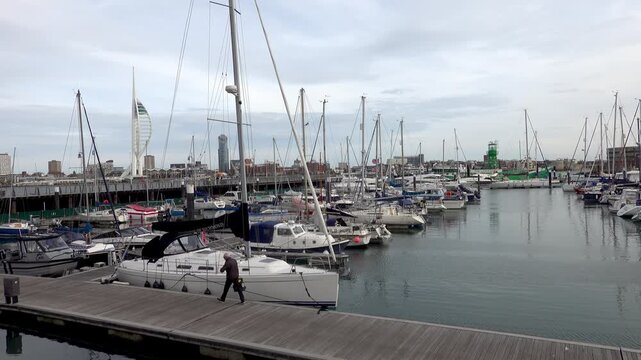 Pleasure boats and yachts moored in Gosport Marina. A man passes