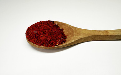 spice on a wooden spoon on a white background