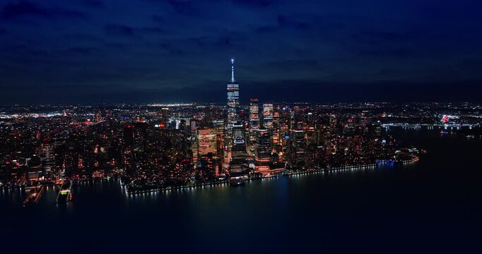 Rising over the calm waterscape of the East River at night. Revealing scenery of spectacular New York with dazzling illumination.
