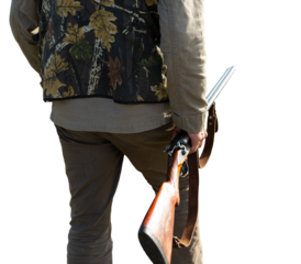 Mature man hunter with gun while walking on field.