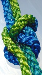 Close-up of a colorful rope knot against a bright background.