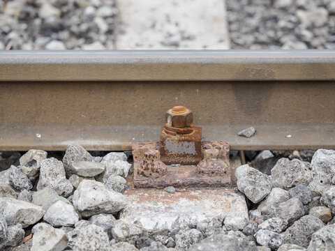 Old rusty bolts securing the side part of a rail and sleeper.
