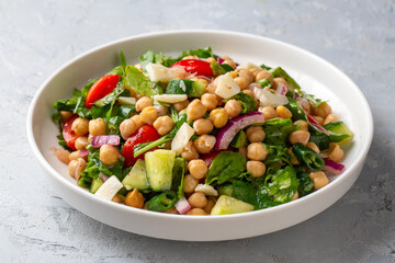Vegetarian chickpea salad with tomatoes, arugula, parsley, spinach and red onion. Healthy food, diet. Top view