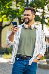 Happy successful satisfied Caucasian man young guy male traveler mobile phone user holding...