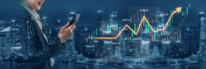 A professional woman in business attire is using her smartphone to analyze stock market trends,...