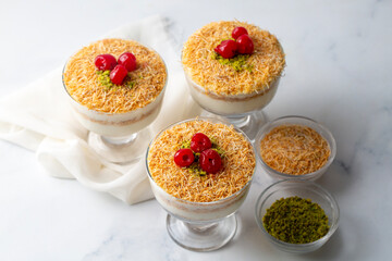 Traditional milky crispy Ramadan dessert custard pudding with roasted kadayif and diced pistachio . Kadayifi Muhallebi