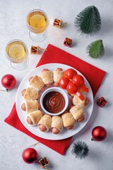 Sausages in dough in the form of Christmas wreath with ketchup sauce for Christmas holidays