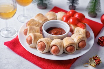 Sausages in dough in the form of Christmas wreath with ketchup sauce for Christmas holidays