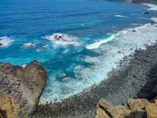 Turquoise Waves Powerfully Crashing on Rocky Shoreline, Creating a Breathtaking View