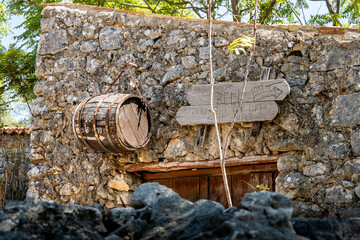 Old, stone wall decorated with signs and wooden barrel on the old barn in the small town of Beli, located on Cres island, Croatia