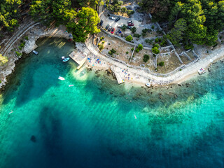 Top down aerial view of beautiful, secluded beach in the small bay of Cres island, Croatia, with beatiful, turquoise sea splashing the sand shore