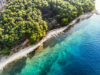 Top down aerial view of beautiful Cres island with olive plantations divided by the old drywalls and beautiful, turquoise sea splashing the shore