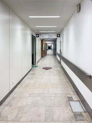 Hospital corridor with bright lighting, clean walls, and smooth flooring, showcasing a modern healthcare environment and emphasizing patient care and accessibility