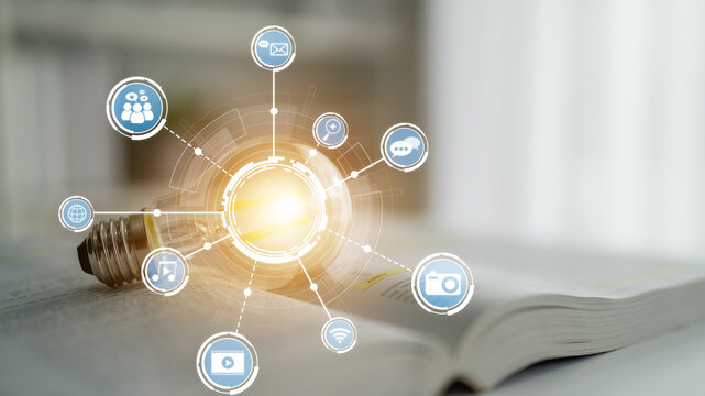 A light bulb shines brightly among digital communication icons on an open book, symbolizing innovation and the fusion of knowledge and technology for learning. Crux