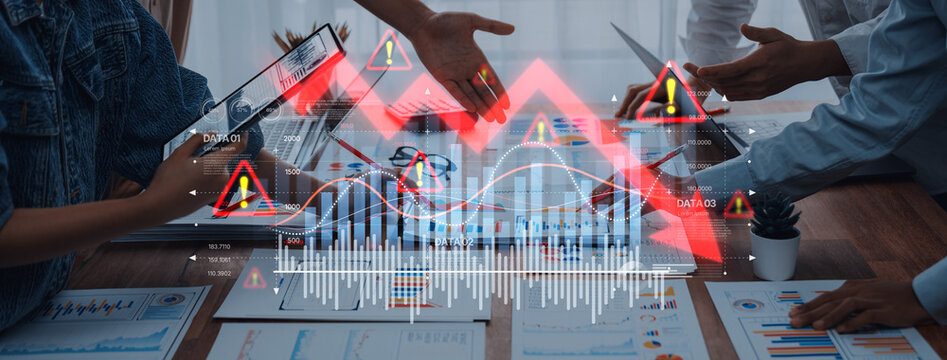 A business team collaborating on data analysis within a modern workspace. Digital interface overlays display graphs and warning signals, emphasizing growth challenges. Trope