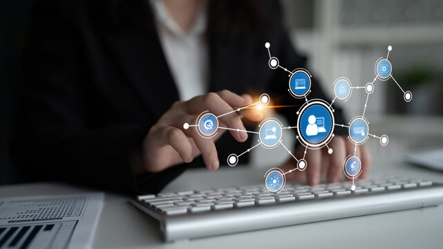 A business professional interacts with a keyboard in a modern workspace, showcasing digital connection icons that symbolize networking and communication concepts. Tessel - Powered by Adobe