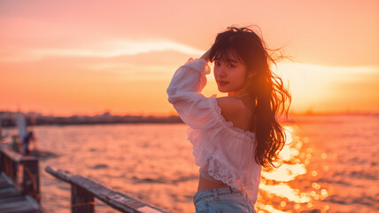 Obraz premium ティーンの日本人少女が夕暮れの桟橋で微笑む