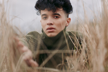 A thoughtful portrait in tall grass communicates authenticity through candid emotion and natural...