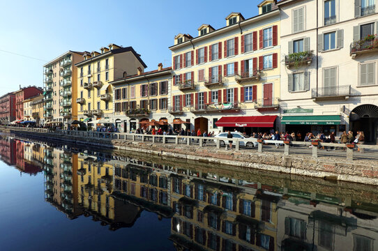Milan, Metropolitan City of Milan, Italy - Oct 18, 2025: Tourists visit restaurants and shops on the banks of the Naviglio Grande canal in the Navigli district of Milan, Italy.