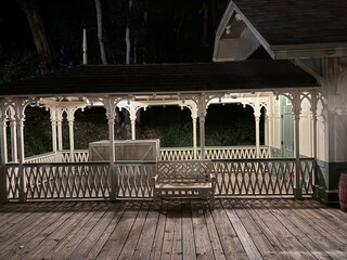 Vintage Train Station at Night: A nostalgic depot with a wooden walkway, illuminated by warm lights under a dark sky, evoking history.