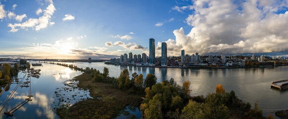 Naklejka premium New Westminster Skyline Over Fraser River at Sunset With Modern High Rise Buildings, British Columbia