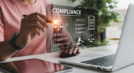Man working on compliance checklist with digital display and laptop  
