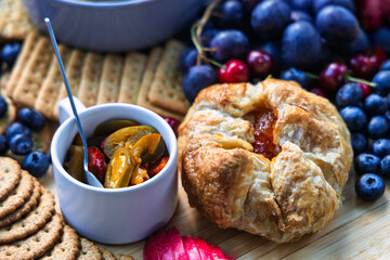 baked brie fruit tart pastry, cheese wrapped in puff pastry and pickled jalapeño peppers with blueberries , grapes and crackers . It is often served as an appetizer .