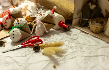 Snowmen crafted from rustic materials among a selection of festive handicrafts and decorations.