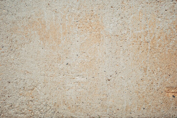 A wall with a rough texture and a few small holes