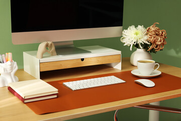 Stylish workplace with computer and brown mat on desk in office, closeup