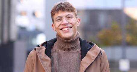 Handsome man in glasses laughing on city street
