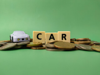 The image is a conceptual representation of the cost of owning a car. It shows a toy car and the...