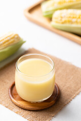 Sweetcorn milk in glass and fresh sweetcorn on white background, Alternative milk from plant, dairy free
