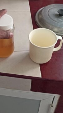 opening a jar of honey to sweeten coffee