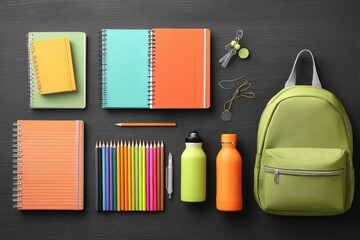 Obraz premium Flat Lay of School Supplies: Backpack, Notebooks, Pencils, and Water Bottles on a Dark Surface