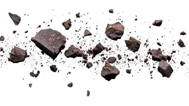 Close-up of scattered dark brown earth fragments against a stark black backdrop